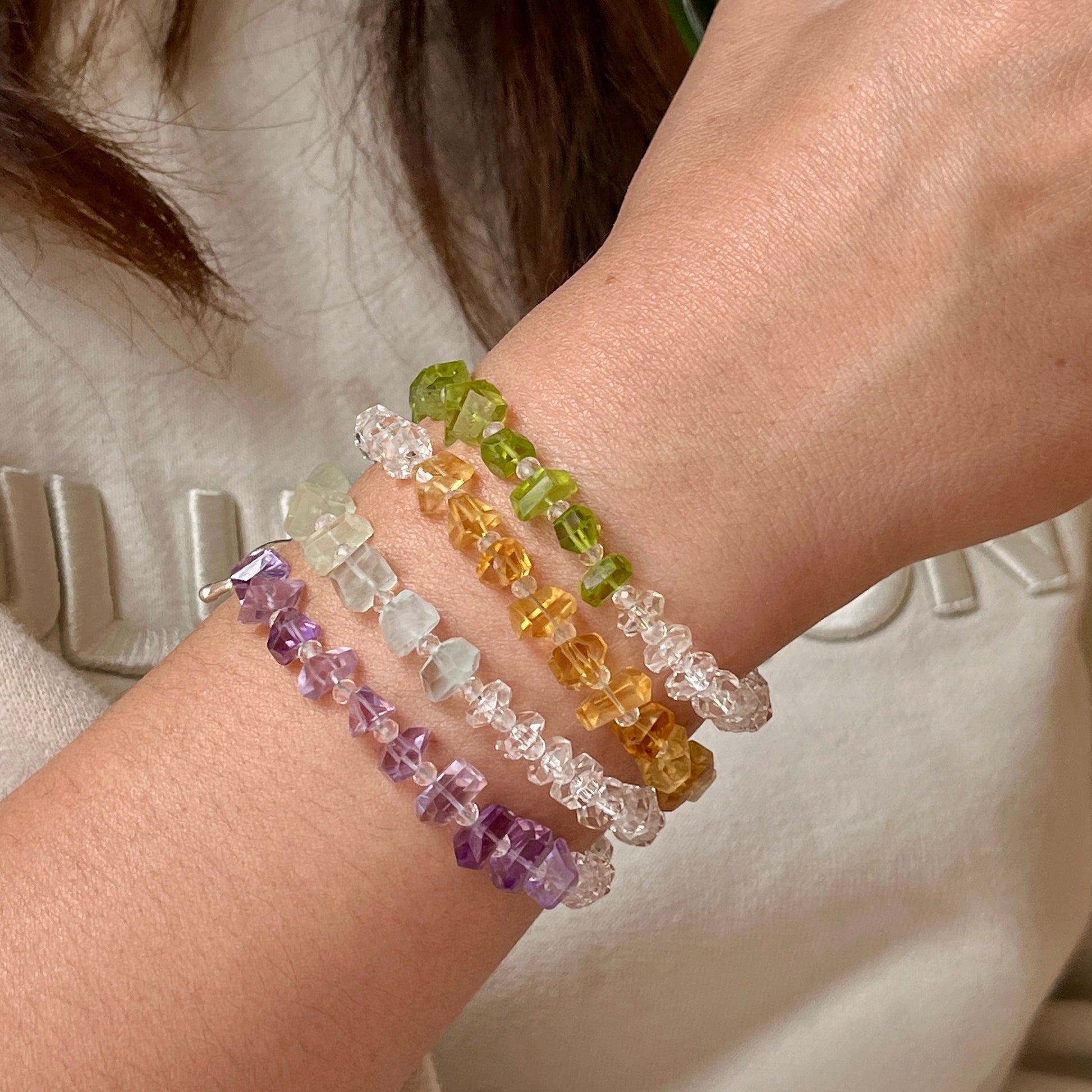 Multicolored beaded bracelets on a wrist with a neutral background
