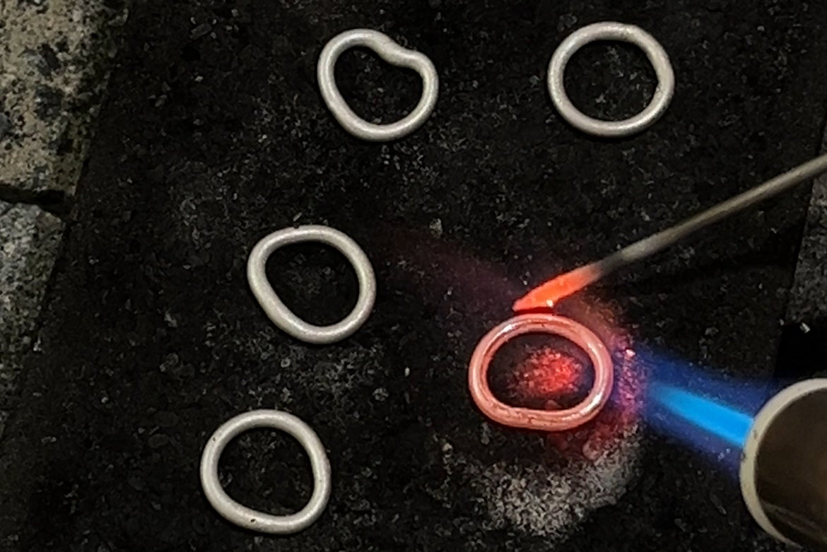 Artisan hand-fusing Argentium silver links for Love Gem Studio Alchemist's Pulse collection.