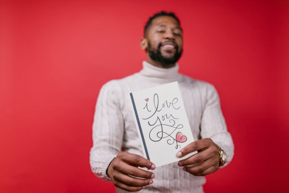 man in white long sleeve shirt holding valentine s day card